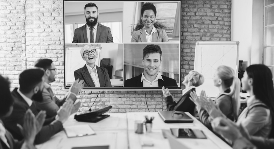 A group of workers clap while they attend a webinar. 