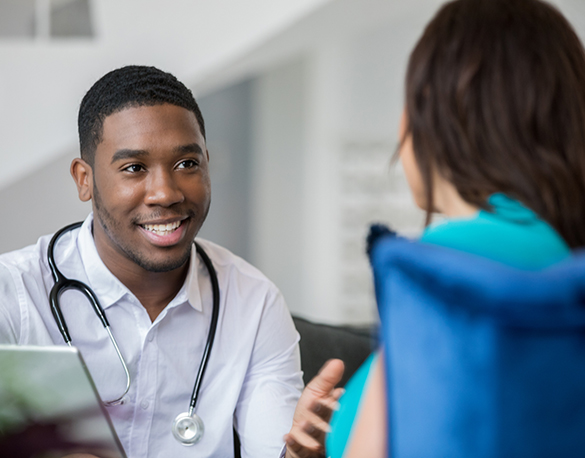 A doctor smiles while helping someone with their mental health. 