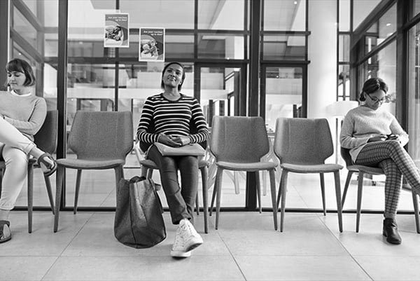 Three patients wait in a waiting room. 