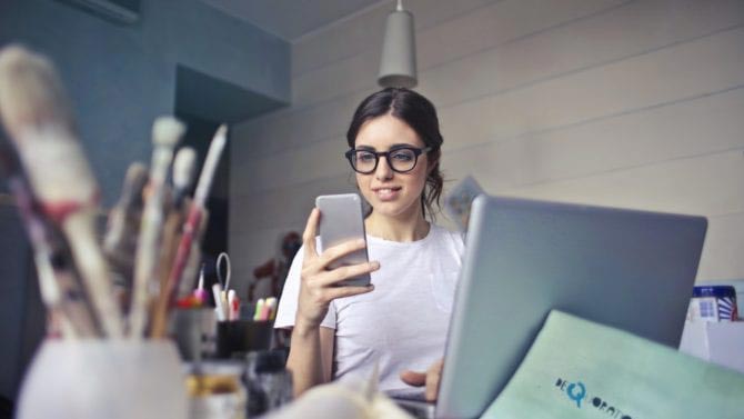 A young woman searches for a doctor on her smartphone.