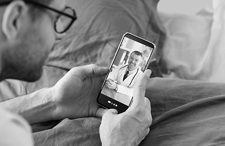 A man goes to an online visit on hie smartphone. 