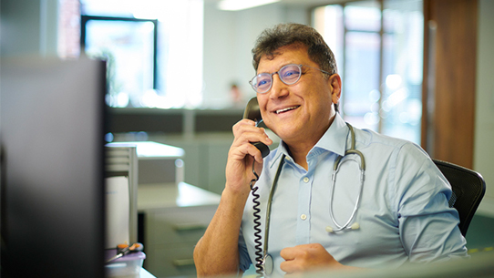 A nurse smiles while answering the phone