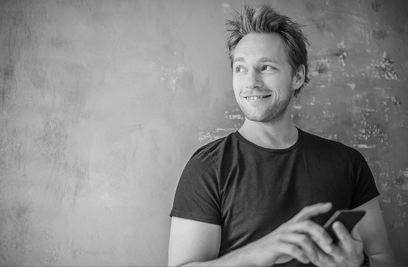 A man smiles as he looks over his shoulder. 