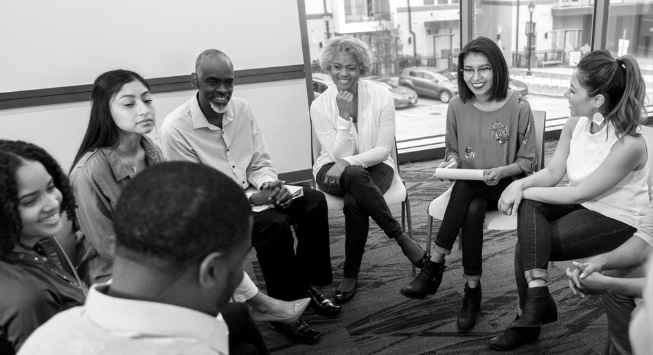 A group of individuals sit in a meeting together