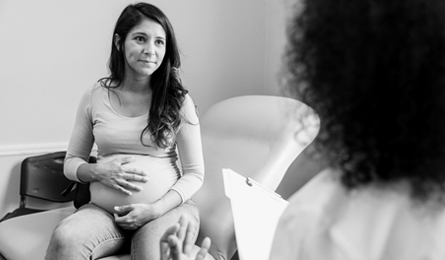 A pregnant woman speaks with a health care provider