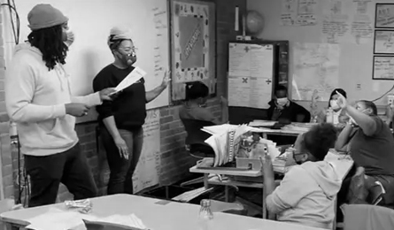 Young students raise their hands in a classroom