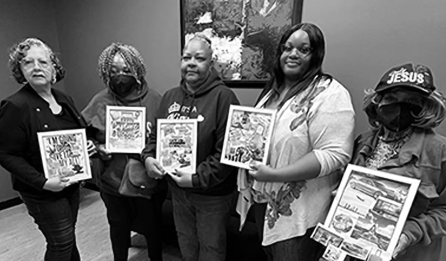 A group of women hold up collages. 