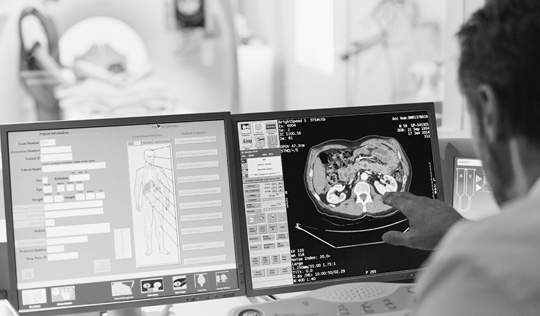 A health care professional looks at digital imaging results
