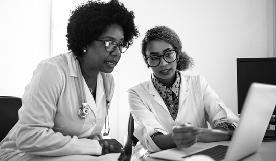 Two females look at a laptop together