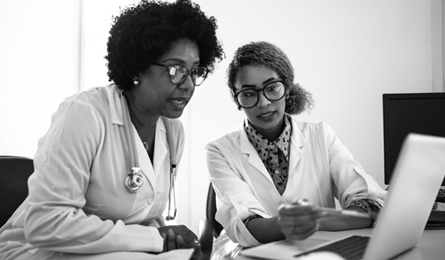 Two females look at a laptop together