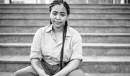 A young woman sits on steps outdoors