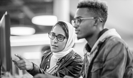 Two students look at a computer screen together