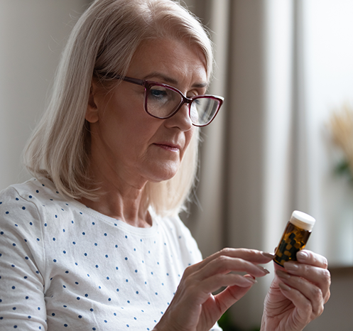 Woman looking at medication bottle
