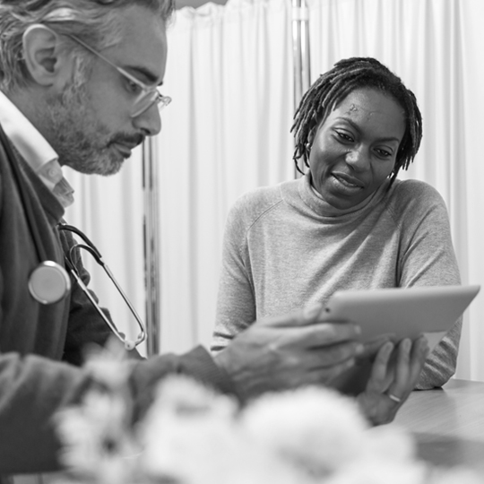 A woman and a health care provider looking at a tablet