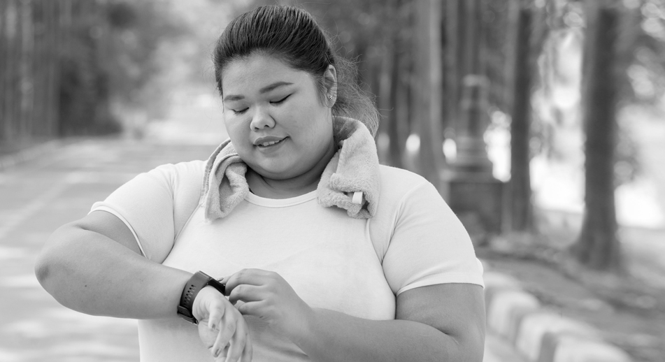 A woman checks her smart watch while exercising 