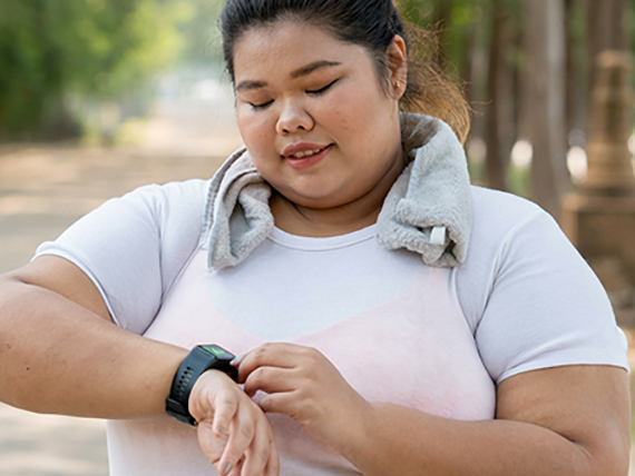 A woman checks her smart watch while exercising 