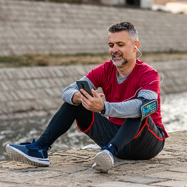 A man sits on the ground and talks on his phone