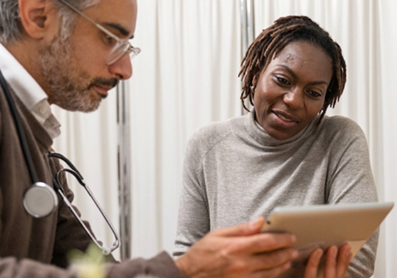 A woman and a health care provider looking at a tablet