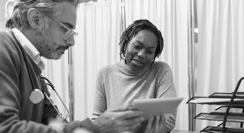 A woman and a health care provider looking at a tablet