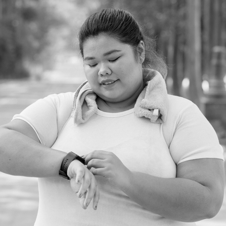 A woman excercising and checking her smart watch
