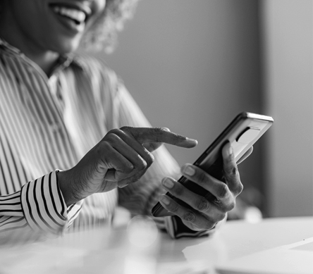 A smiling woman holding a mobile device