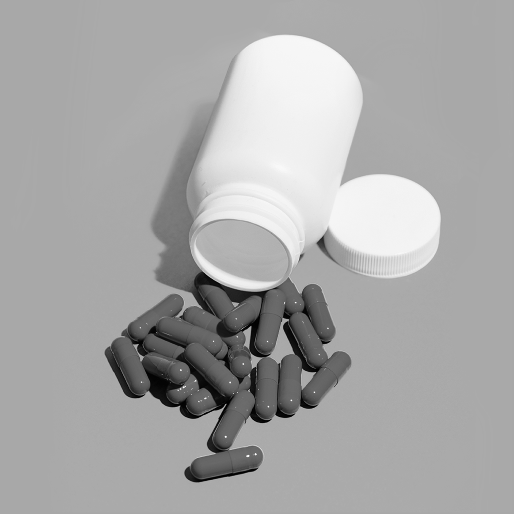 Pills next to an open prescription bottle