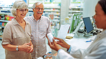 Customers talks to a pharmacist about a prescription.