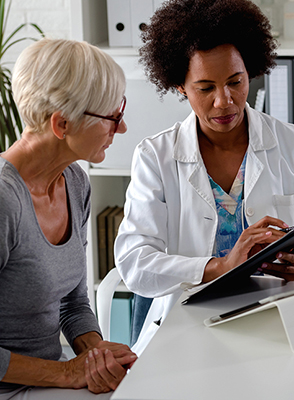 A doctor shows a senior woman her medical chart.