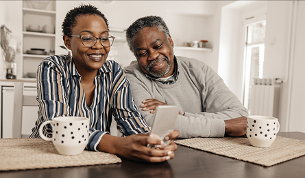 A senior couple navigate a website on their smart phone.
