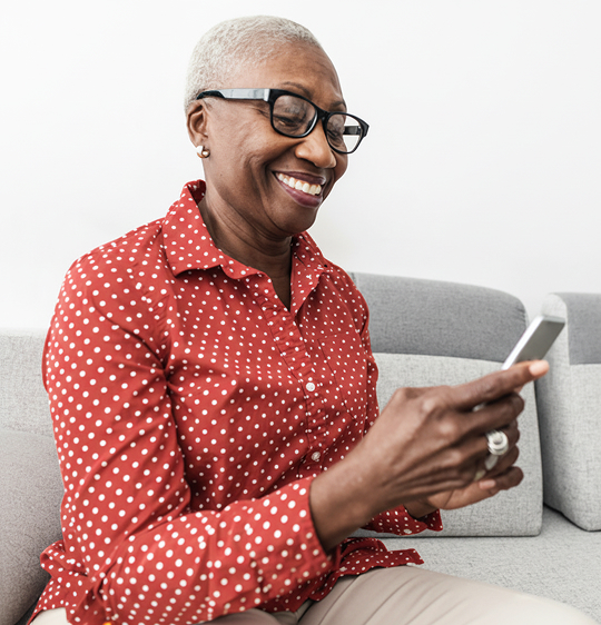  Woman smiles while looking at phone. 