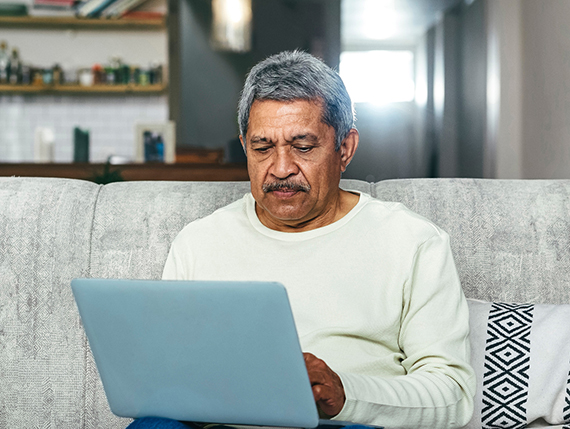 A senior man looking at his laptop computer.