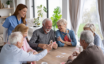 A gathering of elderly people playing cards