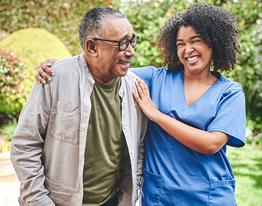 A caregiver and an elderly mas as he's walking