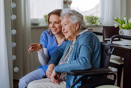 A caregiver embraces her aging loved one.