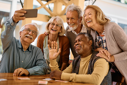 Five older people pose for a selfie