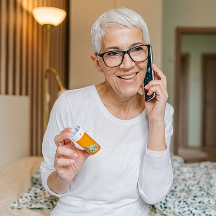 A senior woman talks about her prescription over the phone.