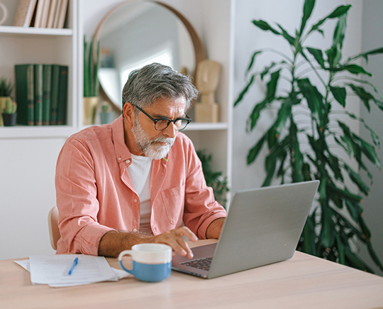 A senior man with Medicare coverage looks at a drug list to see if a prescription is covered.