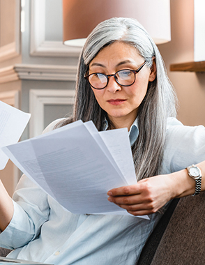 A senior woman reviews some paperwork.