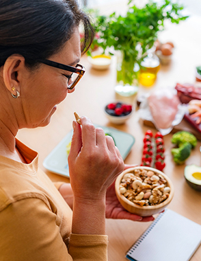 A woman takes a bit of a snack.