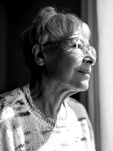 An older woman looking out window