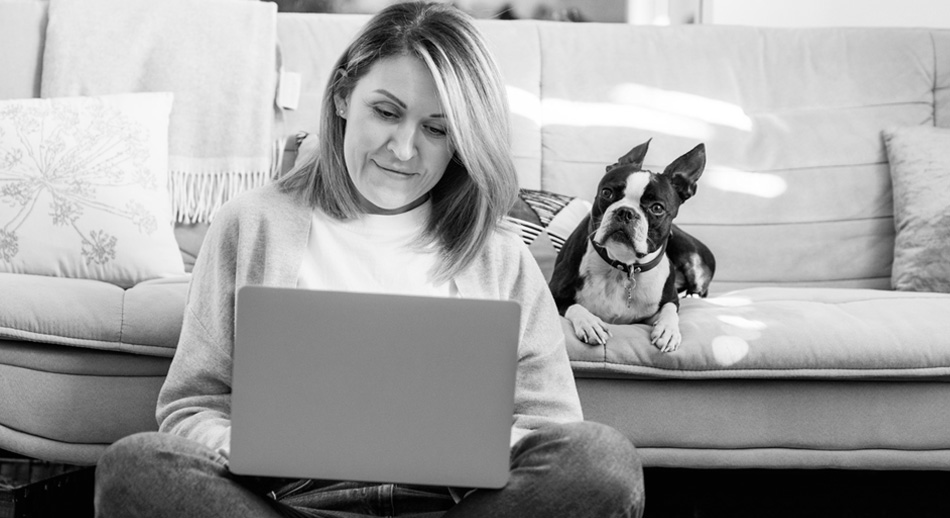 Woman sitting on the floor looking at her laptop