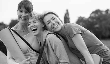 A family laughs together in an open field.