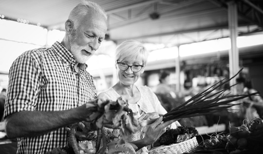 A couple looks at flowers together while shopping.