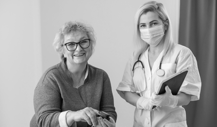 A woman with a Blue Cross doctor reviewing her health assessment. 