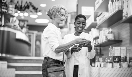 Two women look at health care products together.