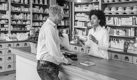 A customer talks to a pharmacist about a prescription.