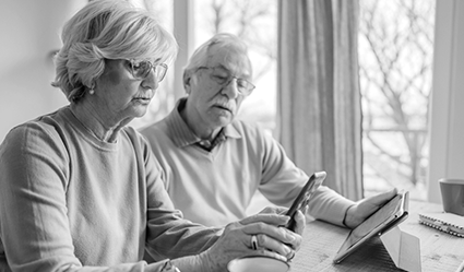 Two seniors look over their health care plans online.