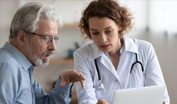 Man looking at screen with female doctor. 