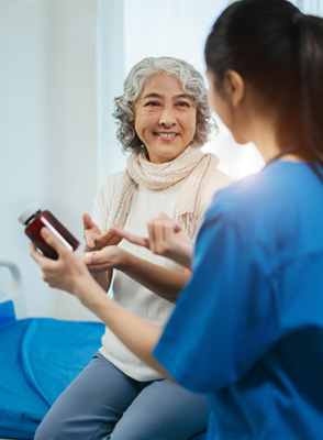 A senior woman talks about her prescription with a health care professional.