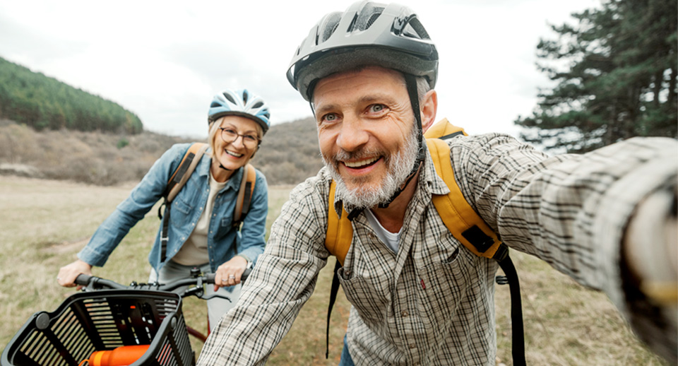 An older man and woman take a break from riding their bicycles